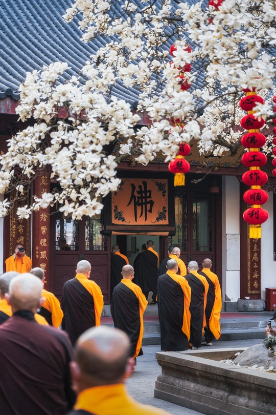 橙色僧袍的僧人在寺庙前面行走