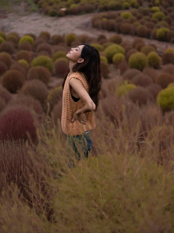 站在一片高草丛中的年轻女子