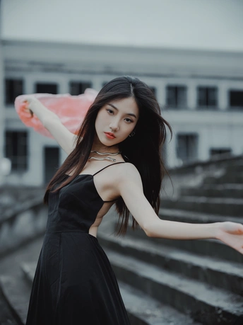 一个穿着黑色连衣裙 手里拿着一把雨伞的美丽年轻女子