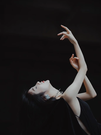 一个穿黑色连衣裙的女人 双手举过头顶