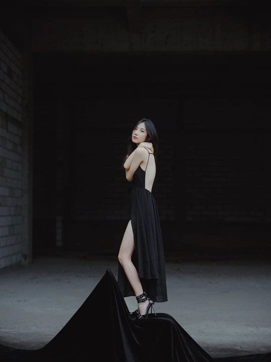 一位穿着黑色连衣裙带有拖尾的年轻女子