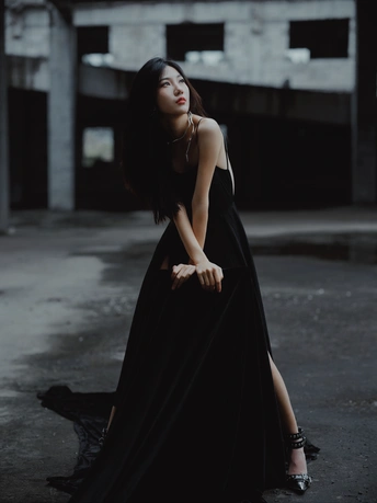 一个穿着黑色长裙的美女在一个废弃的建筑物中