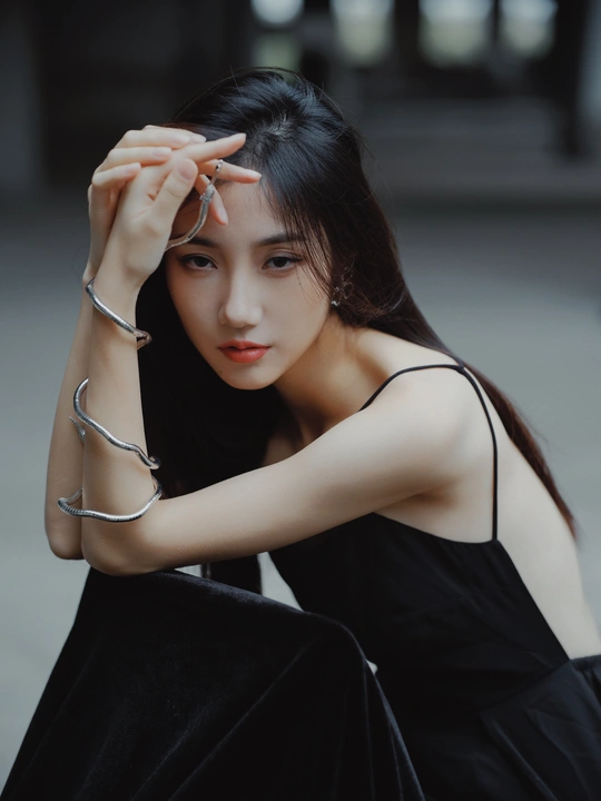 一个穿着黑色连衣裙的年轻女子手里拿着什么东西