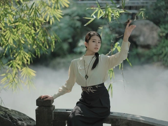 一位年轻女子在河上的桥上摆姿势