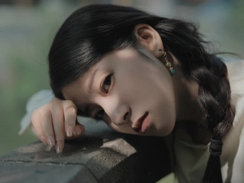 一位年轻女子倚靠在墙上 脸颊贴在墙上