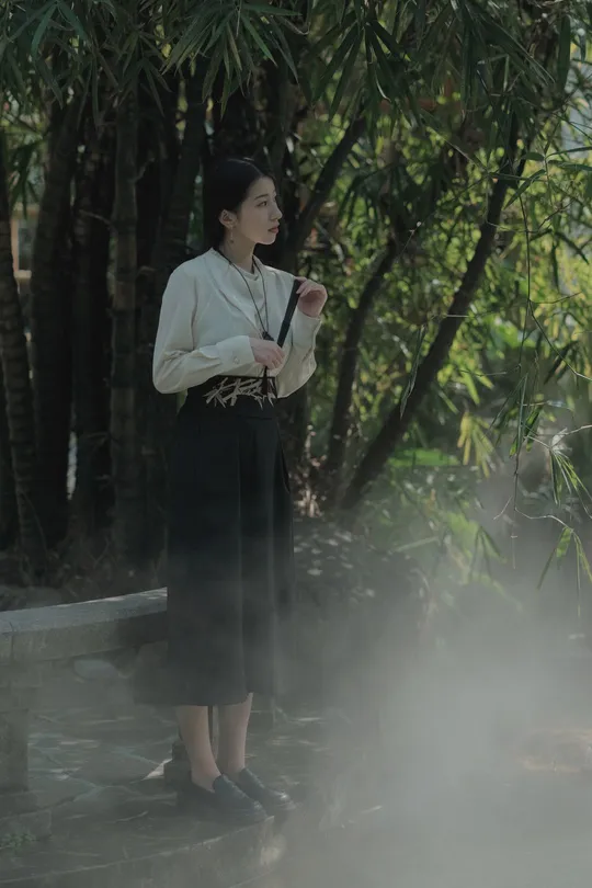 一个女士 带着一把白伞 正在抽烟。