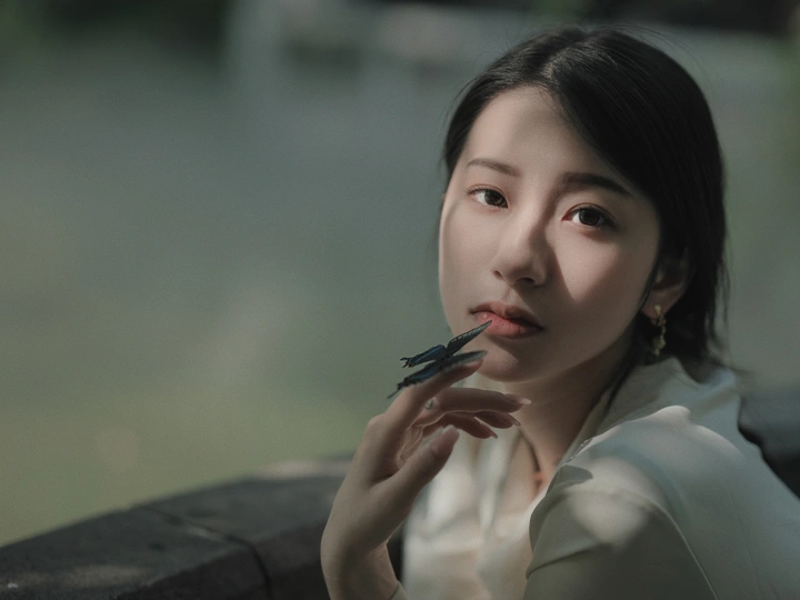 一位叼着烟卷、手捂住嘴唇的年轻女子