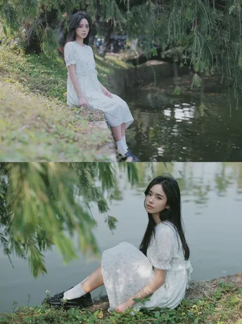 一个美丽的年轻女子穿着白色裙子坐在池塘或河边 周围有树木和水。