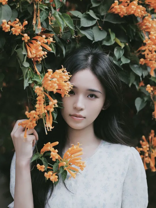 一位年轻女子头戴橙色花朵的肖像