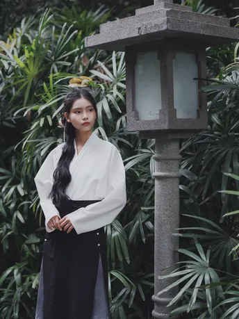 一位穿着黑白衣服的女性在传统花园中摆姿势