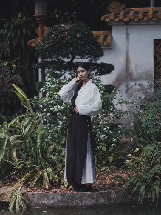 一位穿着和服的女子站在池塘边