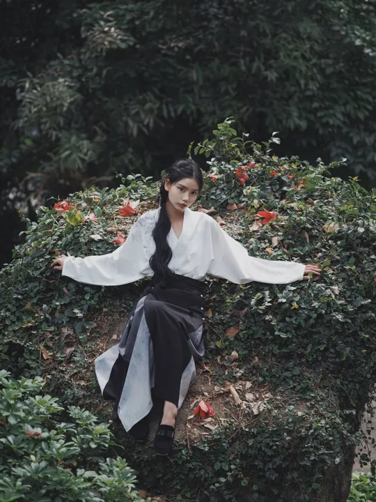 一位坐在花园中的灌木丛上的女人