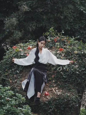 一位坐在花园中的灌木丛上的女人