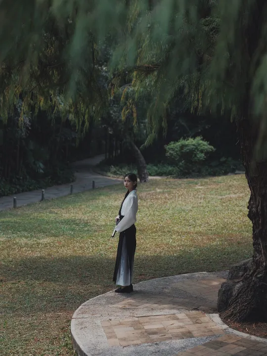 一位站在公园树下的女士