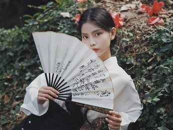 一位穿着黑白和服的女士手里拿着一把白伞