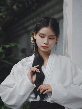 美丽的年轻女子 长发披肩 身着白色和服 站在户外。