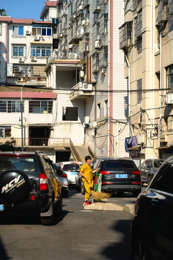 一条有汽车、建筑物的城市街道 一个人拿着黄色消防栓站在街道中央