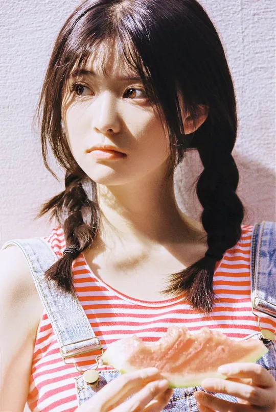 一位年轻女子正在拿着一个西瓜