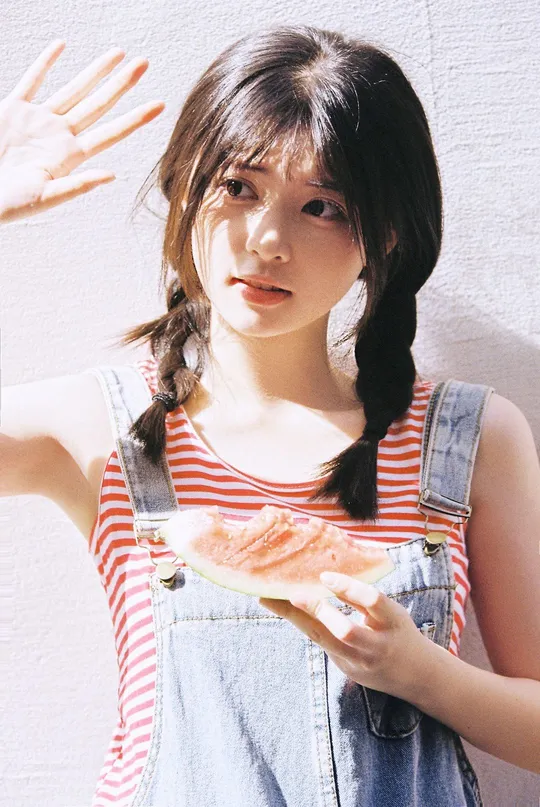 一位年轻女子拿着披萨和一小个西瓜