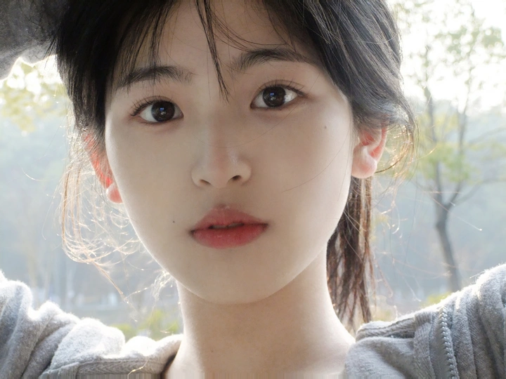 一位戴帽子的年轻女子正在对着相机看窗外