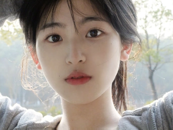 一位戴帽子的年轻女子正在对着相机看窗外