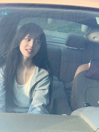 一位年轻女子坐在汽车驾驶员座位上