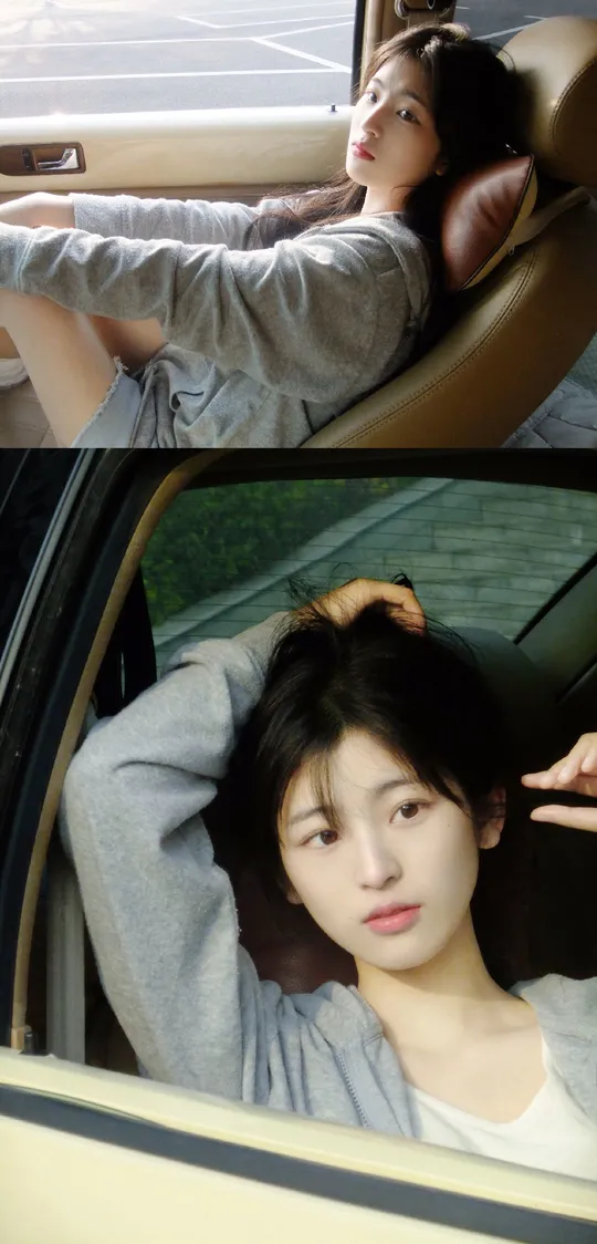 一位女性坐在汽车里 正在通过窗户向外看。