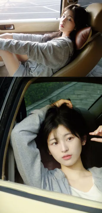 一位女性坐在汽车里 正在通过窗户向外看。