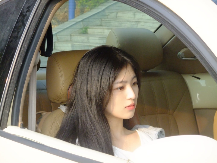 一位年轻女子坐在汽车驾驶员座位上