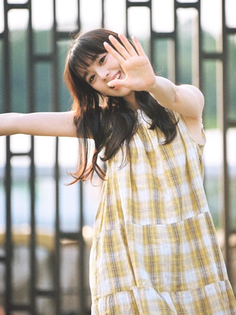 一位穿着格子衬衫和黄色棋盘裙的年轻女子
