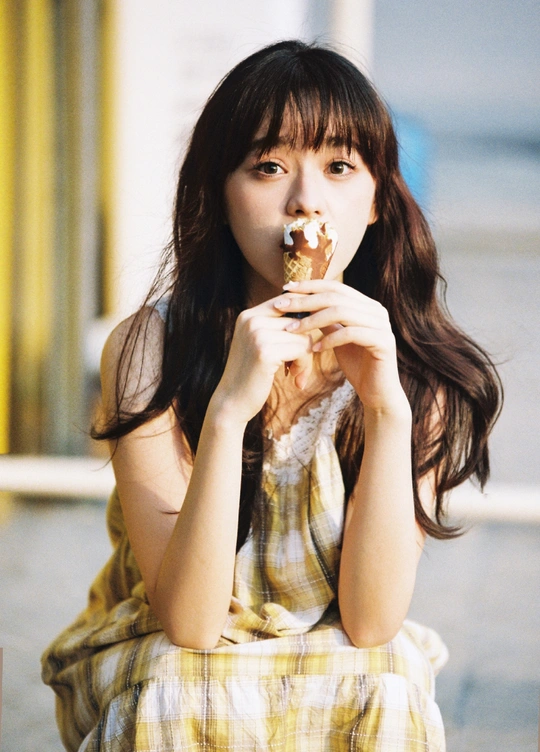 一位穿着连衣裙的年轻女子正在吃食物。