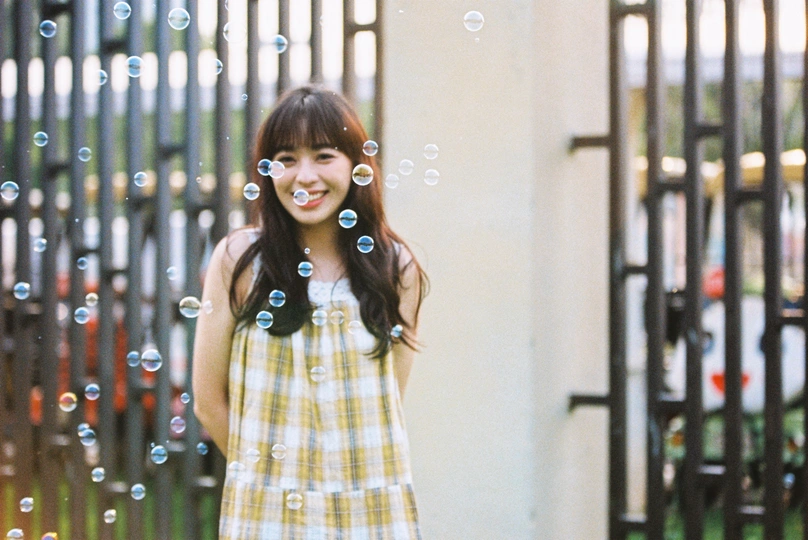 站在围墙前面的黄色连衣裙年轻女子