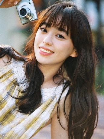 一位年轻女子手持相机拍照