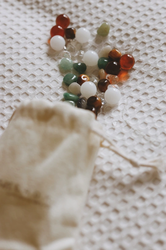 桌子上的一块白布 上面有珠子和剪刀