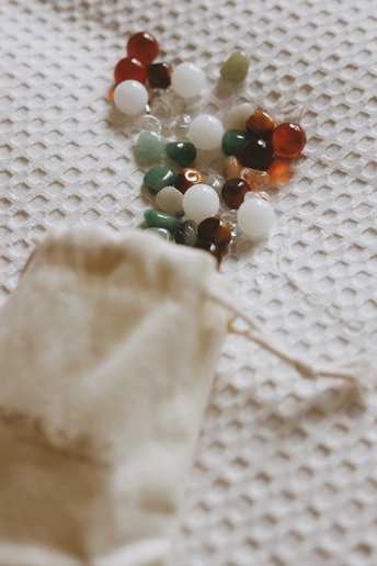 桌子上的一块白布 上面有珠子和剪刀