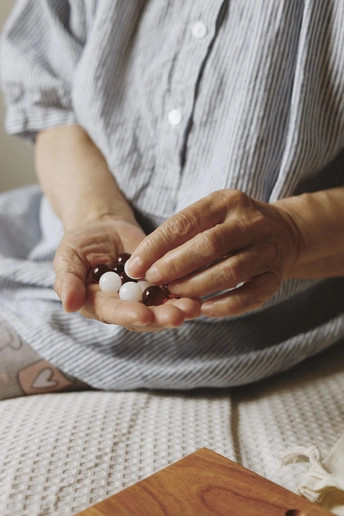 手里拿着白色药丸的老妇人