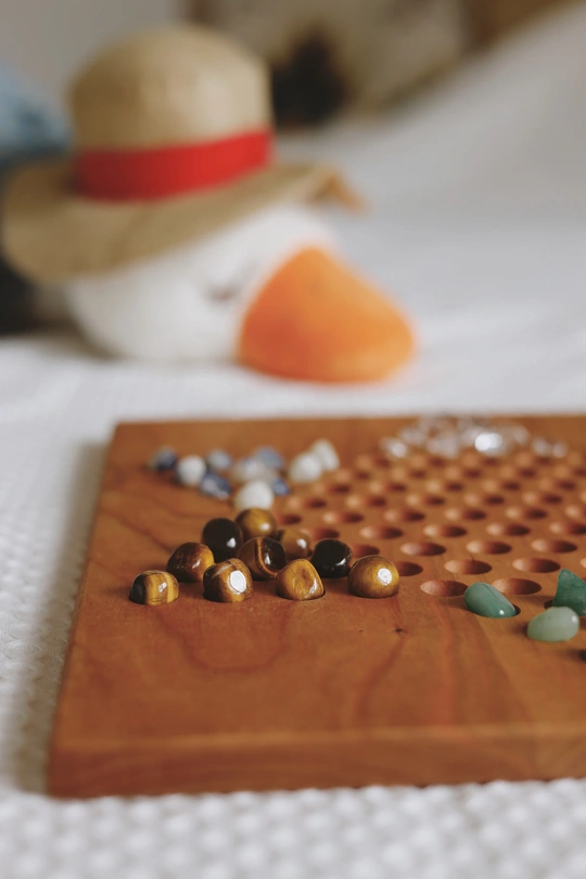 床边桌子上的一块带珠子的木板和一顶帽子