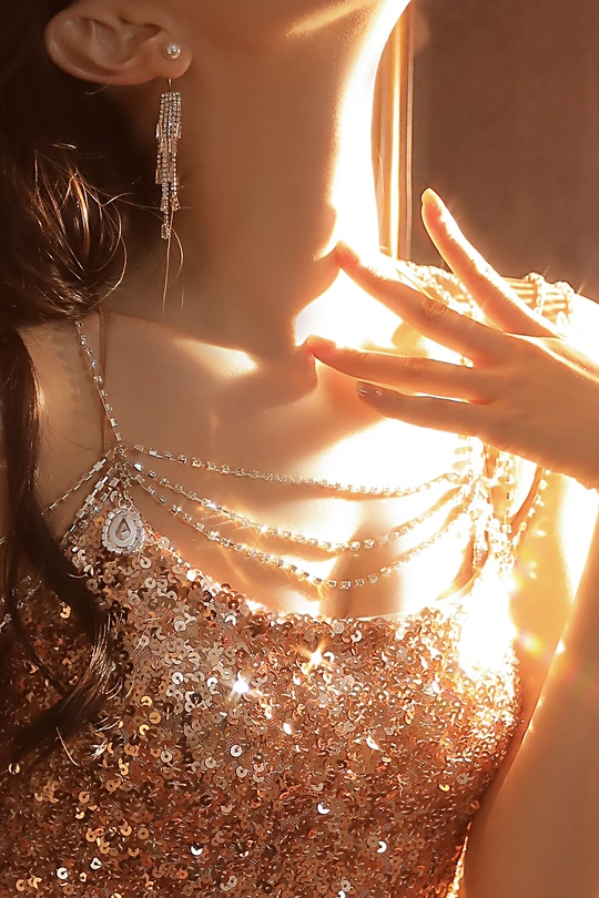 一位穿着闪亮连衣裙的女人正在窗户边向外看