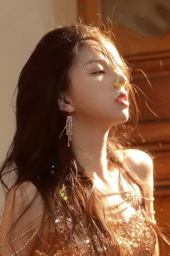 美丽的年轻女子穿着轻便连衣裙 耳环在阳光下闪闪发光。