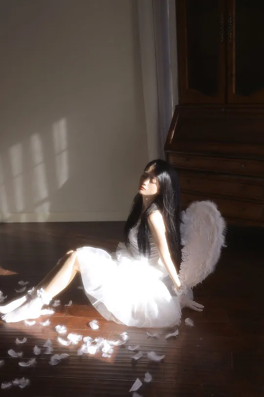 一个穿着白色连衣裙的小女孩坐在光线昏暗的房间里