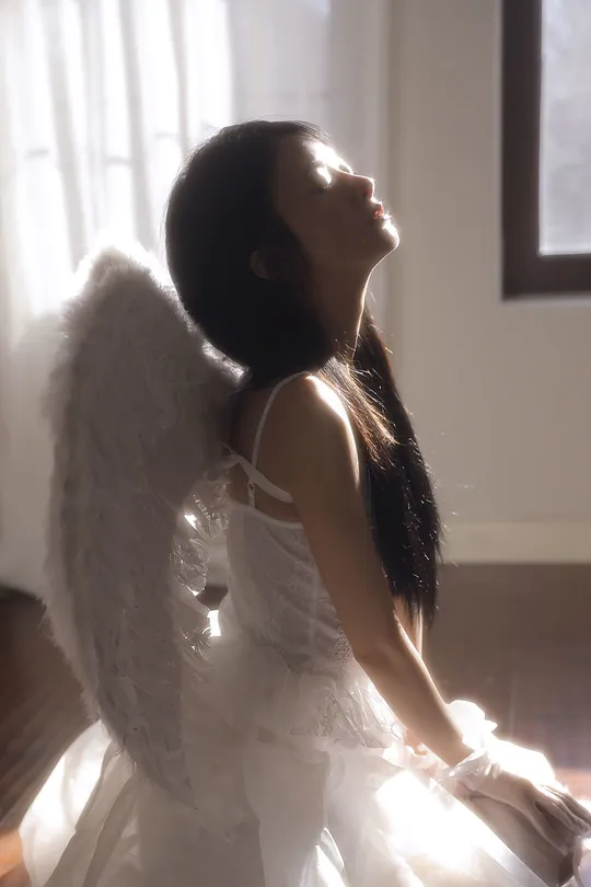 一位穿着白色连衣裙带有翅膀的女子的尸体躺在窗户前地板上