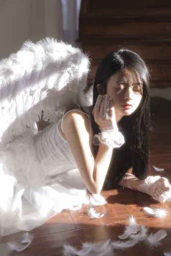 一个带有白色羽翼的天使娃娃躺在地板上