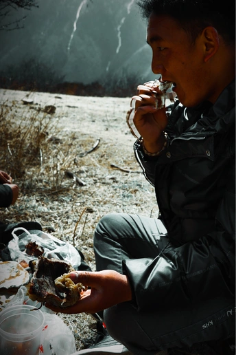 一个男人和其他人坐在炉火旁用杯子喝水