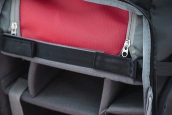 一个黑色的背包 口袋里有一把剪刀。