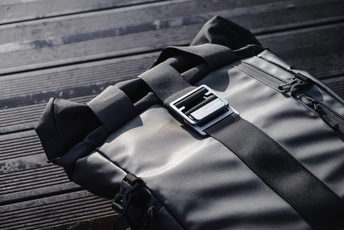 一个黑色背包坐在木地板上