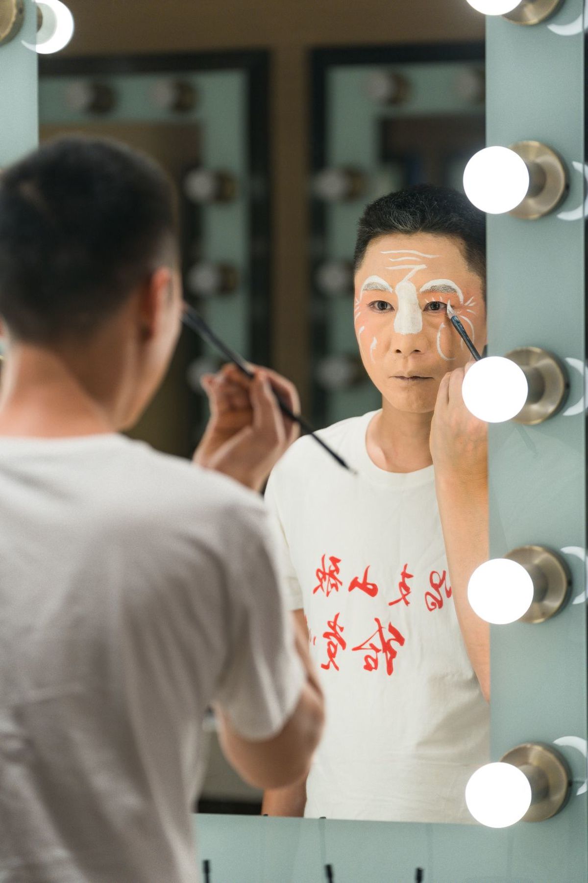 一位年轻女子站在镜子前 脸上戴着面具。