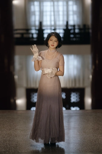 一位穿着长袍和手套的年轻女子站在跑道上