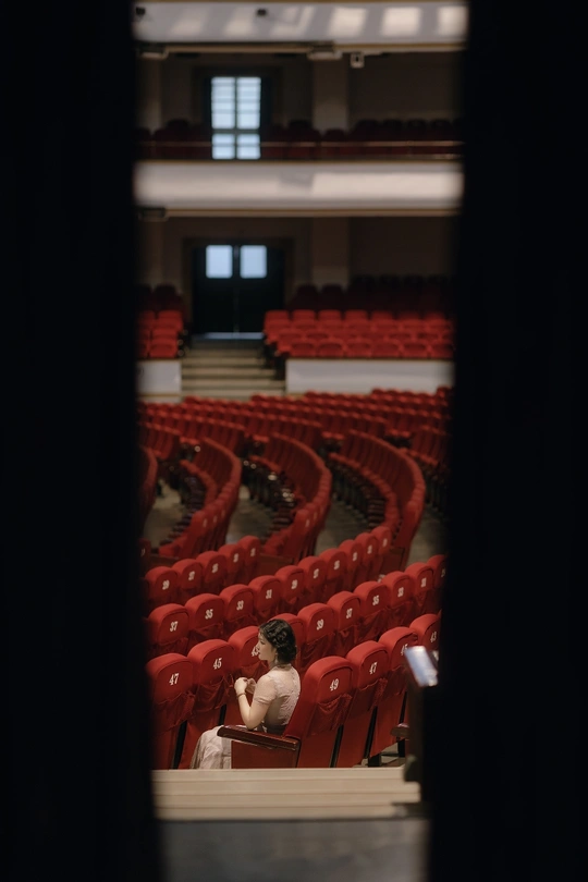剧院舞台上的照片 空座位 一个人坐在红色的观众席上