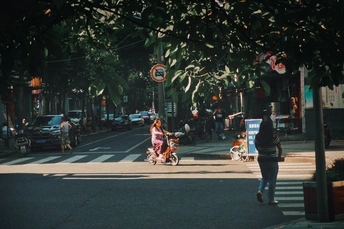 一个人骑着自行车穿过城市的街道 有人在散步 还有一个人在推婴儿车