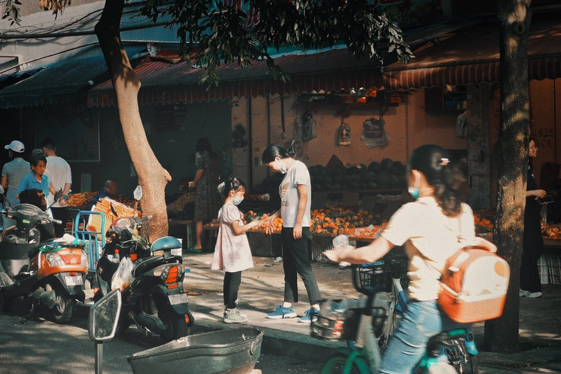 一个骑自行车的男人在街上挨着几个人